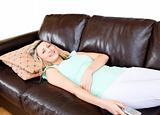 Unstressed woman lies on sofa and watches TV