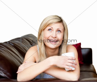 Laughing woman lies on a brown sofa