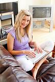 Cute woman sitting on sofa and working 