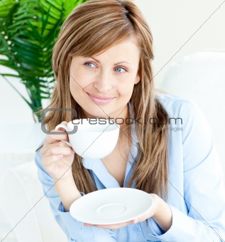 Attractive woman sitting and drinking out of a cup