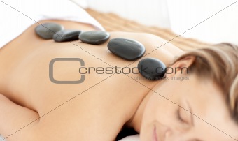 Relaxed woman with hot stones on her back 