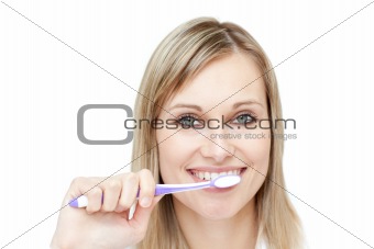 Portrait of a blond woman brushing her teeth
