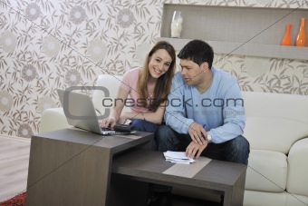 young couple working on laptop at home