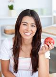 Beautiful woman eating an apple smiling at the camera