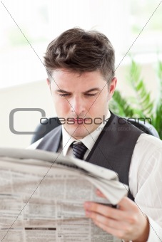 Concentrated businessman reading a newspaper
