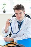 Cute male doctor working in his office against a white background
