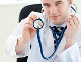 Portrait of a charming male doctor holding a stethoscope 