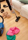 Blond young woman vacuuming the living-room
