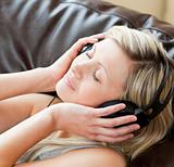 Relaxed woman with headphones on lying on a sofa 
