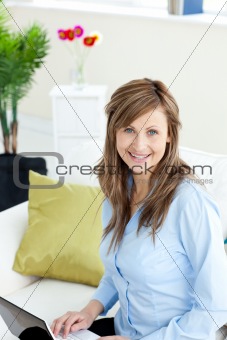 Delighted businesswoman using a laptop