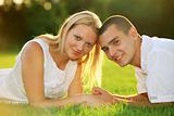 Young happy couple lying down on grass