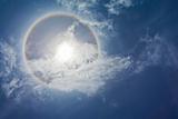 Sun with circular rainbow and clouds