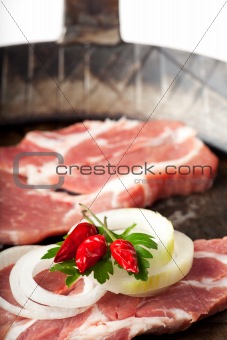 raw pork steak in a iron pan