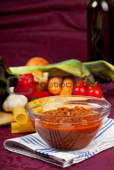bowl with sauce bolognese and raw vegetables
