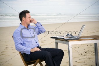 Business man with office on the beach
