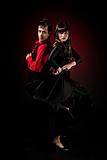 Young couple passion flamenco dancing on red light background.