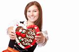 Young happy smiling woman in Oktoberfest dirndl holds heart
