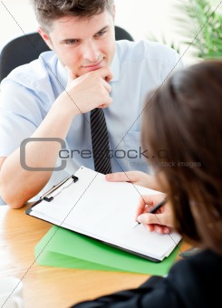 Young salesman looking at female customer sign a contract