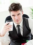 Portrait of confident businessman holing a cup od coffee in the 