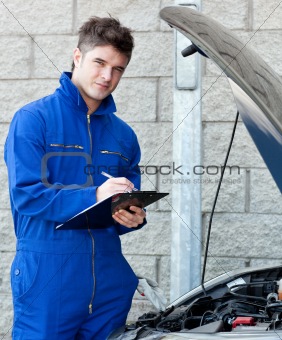 Attractive mechanic writing on a clipoard