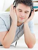 Positive young man listen to music with closed eyes