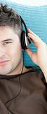Charming young man listening to music with headphones