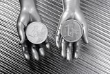 two silver euro coins in futuristic robot hands