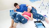 Young couple relaxing after painting a room