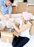 Ambitious young couple unpacking boxes with glasses