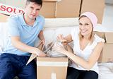 Smiling young couple unpacking boxes with glasses