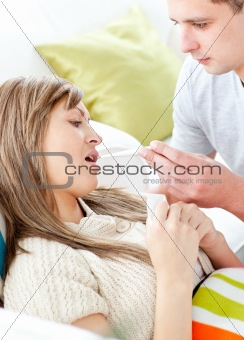Assertive man giving his girlfriend a thermometer 
