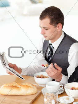 Businessman eating cereals while reading the news