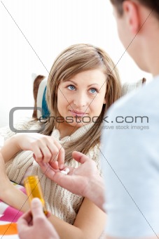 Caring boyfriend giving his ill girlfriend pills