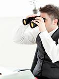 Close-up of a young businessman looking through binoculars isola