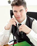 Attentive businessman talking on phone looking at the camera