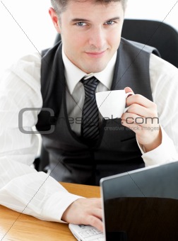 Jolly young businessman looking at the camera holding a coffee