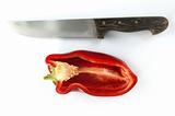 Red pepper and kitchen knife over white