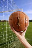 Football ball in hand net soccer goal