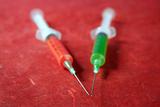 red and green syringe over red background