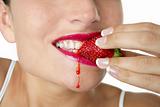 Closeup macro of woman eating strawberry
