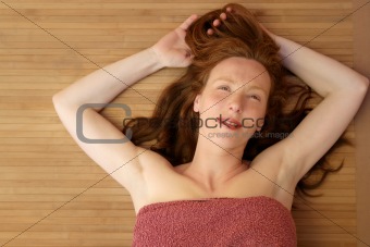 Beautiful redhead woman liying on bamboo