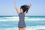 Beautiful summer brunette girl jumping on the beach