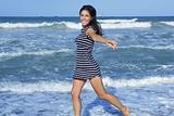 Beautiful summer brunette girl jumping on the beach
