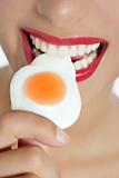 Beautiful woman mouth eating a jelly egg