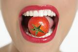 Eating a red tomato macro of woman mouth
