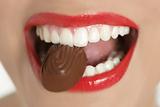 Chocolate sweet in beautiful woman mouth