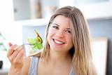 Cute woman eating a salad in the kitchen at home