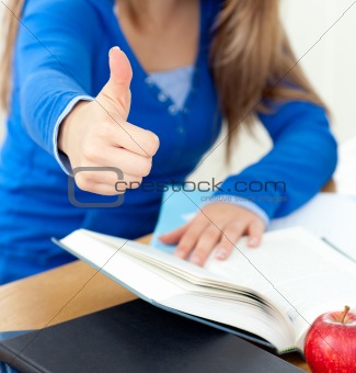 Blond woman reading a book thumb up