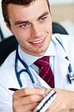 Attractive male doctor writing a perscription 