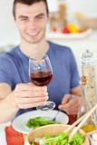 Caucasian man eating a healthy salad with some wine 